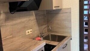 Una cocina con lavamanos, armarios y salpicadero de azulejos.