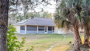 A residential area with a paved pathway leading to a house with a garage. - Executive Studio (Lehigh Acres)