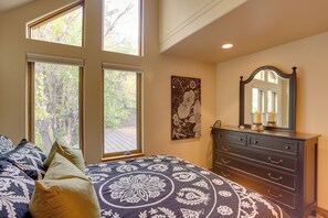 A bedroom with a bed, dresser, and large windows. - On Main St: 2 Mtn-View Units w/ Yard in Ouray (Ouray)