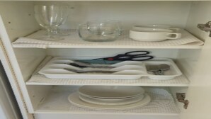 A kitchen cabinet with shelves containing various kitchenware items. - Cosy Studio Retreat in Porirua. perfect for a peaceful getaway or business trip. (Porirua)