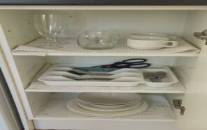 Un meuble de cuisine doté d’étagères contenant divers ustensiles et accessoires de cuisine.