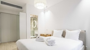 Una habitación de hotel con cama, mesita de noche, espejo y armario.