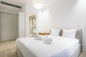 Ein Hotelzimmer mit Bett, Nachttisch, Spiegel und Kleiderschrank.
