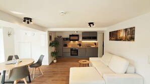 Een moderne woonruimte met een eethoek, keuken en een groot raam.