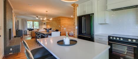 Una cocina moderna con una isla central, electrodomésticos integrados y un comedor con vistas.