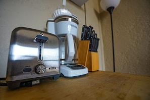 Una encimera de cocina con un tostador, una cafetera y un bloque de cuchillos.