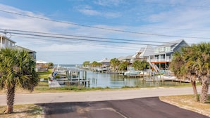 A marina with boats, waterfront houses, and a road leading to the water. - Walk to Beach! Waterfront Beach House w/ Deck (Dauphin Island)