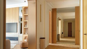 A spacious hallway with wooden flooring, a seating area with a sofa, and a television. - Luxury A/C Apt - 10P/4BDR - Arc de Triomphe (Paris)