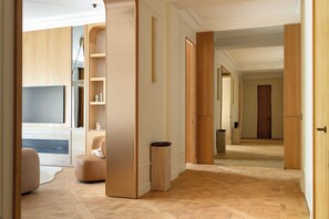 Ein geräumiger Flur mit Holzboden, einer Sitzecke inklusive Sofa und einem Fernseher.