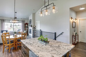 A spacious kitchen with a large island, wooden dining table, and chairs, a ceiling fan, and pendant lights. - Next to Public Golf Course! Kalispell Townhome (Kalispell)