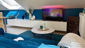 Un salon moderne avec un téléviseur, un canapé et des objets de décoration.