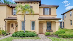 A two-story building with a beige facade, a central entrance with a door, and a small porch area. - Pet-Friendly Townhome 9 Mi to Disney w/ Lazy River (Davenport)