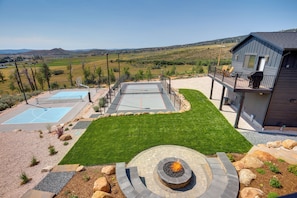 A residential property with a basketball court, a swimming pool, a fire pit, and a view of the surrounding landscape. - Luxury Bear Lake Getaway w/ Sports Court & Hot Tub (Garden City)