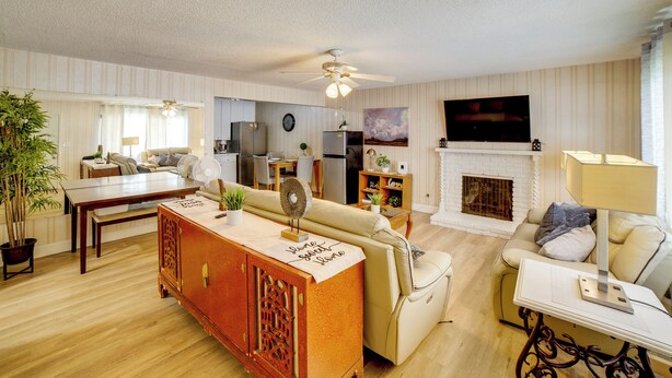 A living room with a sofa, a dining table, a TV, and a fireplace. - Family Home 5 Mi to Dtwn Riverside & Hospital! (Riverside)