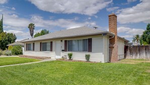 A single-story house with a brick chimney, a front porch, and a well-maintained lawn. - Family Home 5 Mi to Dtwn Riverside & Hospital! (Riverside)