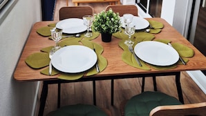 A dining table set with plates, glasses, and cutlery, surrounded by chairs. - Renovated duplex apartment in residence on 3rd floor with elevator. (Roscoff)
