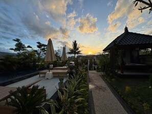 A rooftop garden with seating, umbrellas, and a small pavilion. - Villa Bagus (Banjar)