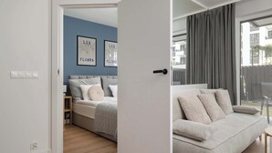 A modern bedroom with a bed, a bedside table, and a wall with two framed pictures.