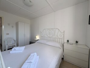 A bedroom with a bed, a nightstand, a chair, and a wardrobe. - Villa in Marina Di Ragusa with 3 bedrooms sleeps 7 (Marina Di Ragusa)