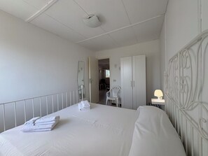 A hotel room with a large bed, a wardrobe, a desk with a lamp, and a chair. - Villa in Marina Di Ragusa with 3 bedrooms sleeps 7 (Marina Di Ragusa)