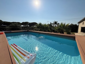 A swimming pool with a wooden deck and a ladder leading into the water. - Villa in Marina Di Ragusa with 3 bedrooms sleeps 7 (Marina Di Ragusa)