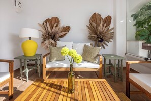 A room with a wooden floor, a sofa with cushions, a yellow lamp, and decorative dried plants. - Aloha Royal Marbella, 2BR Wonderful apartment in Nueva Andalucia (Marbella)