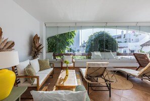 A modern living room with a sofa, chairs, a coffee table, and a view through large windows. - Aloha Royal Marbella, 2BR Wonderful apartment in Nueva Andalucia (Marbella)