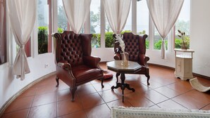 Una habitación con dos sillones de cuero, una mesita y un armario.