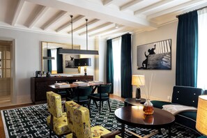A hotel room with a dining area, a sofa, a round table, and a painting on the wall. - Casa J.K. Place Roma (Rome)