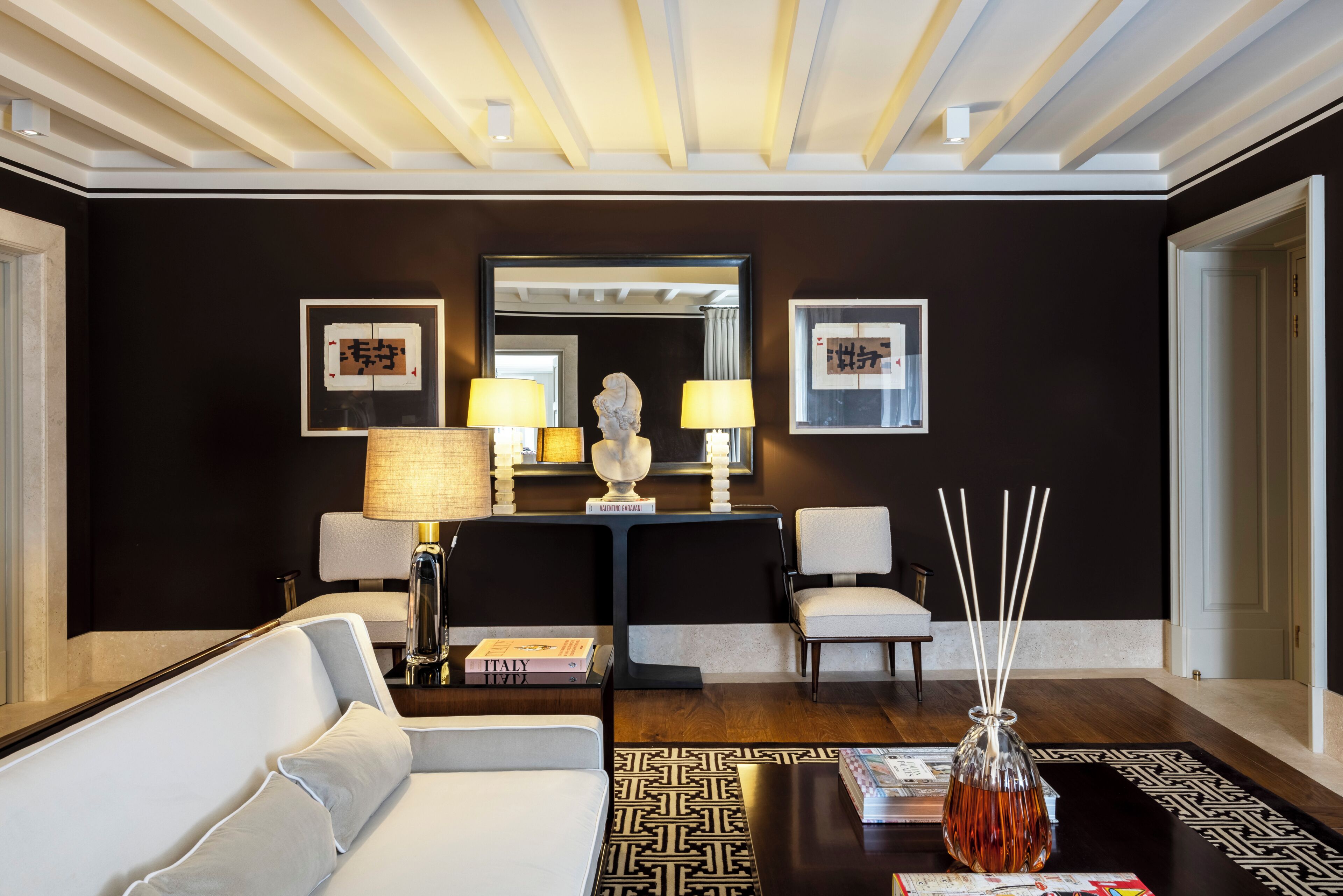 A modern living room with a sofa, a coffee table, a lamp, and a decorative vase.