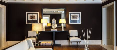 A modern living room with a sofa, a coffee table, a lamp, and a decorative vase.