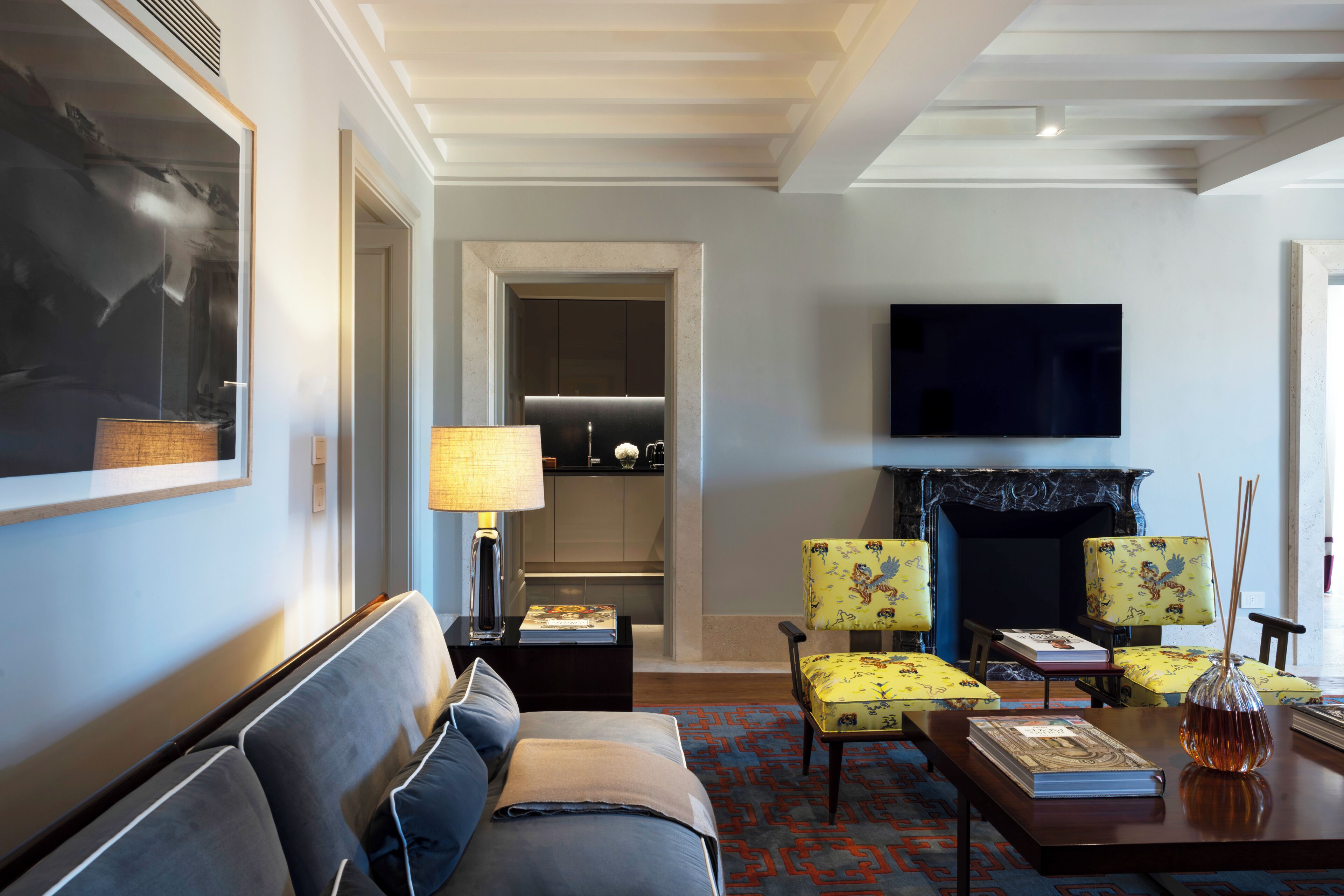 Una sala de estar moderna con sofá, sillones, televisor de pantalla plana, chimenea y estantería.