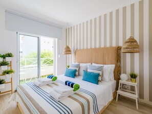 Ein Hotelzimmer mit einem Bett, einem Nachttisch und Blick ins Freie.