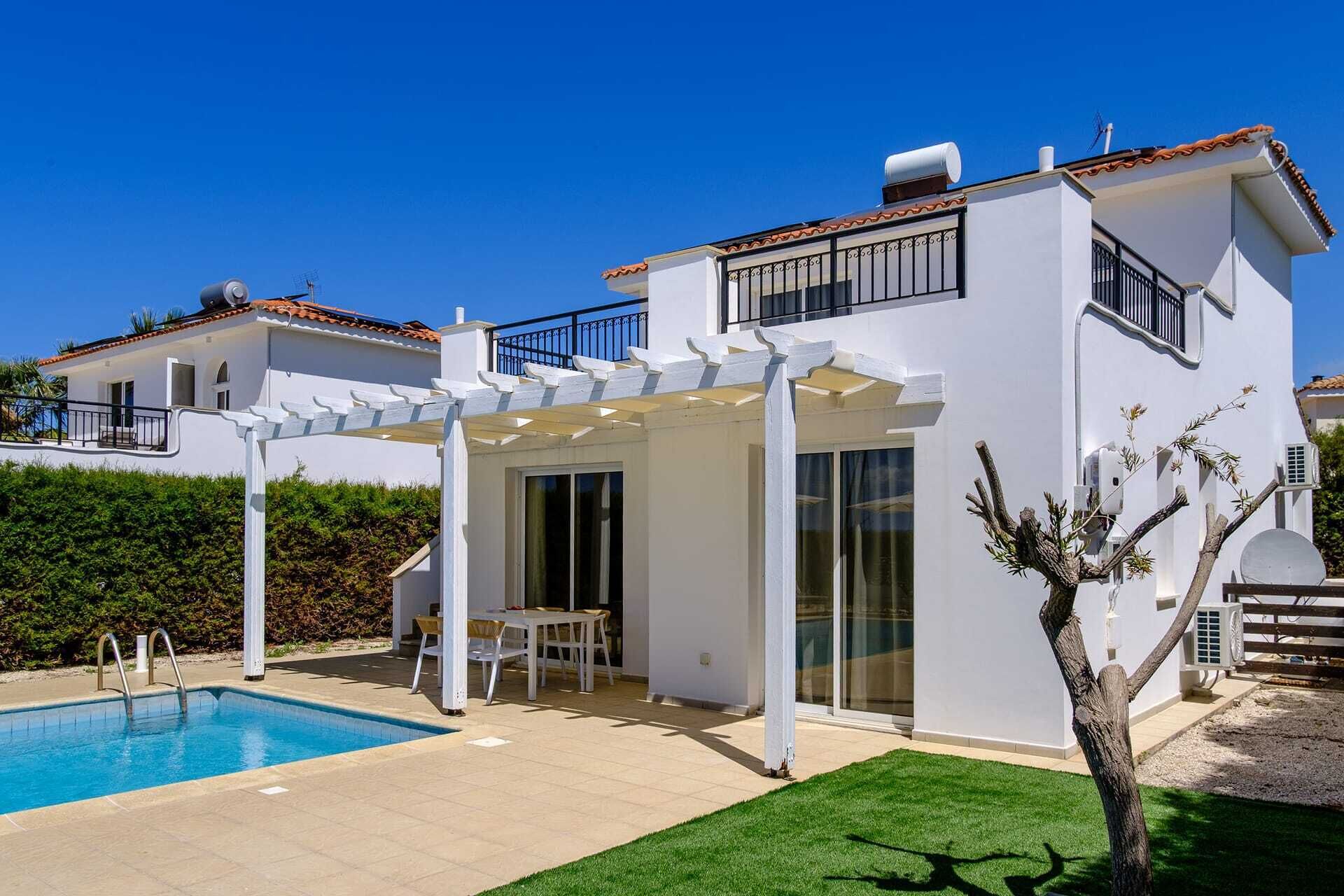 A modern two-story house with a swimming pool, a covered patio, and a well-maintained lawn.