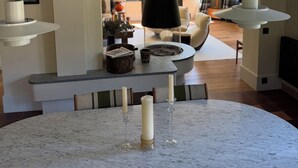Ein modernes Wohnzimmer mit Kamin, einem runden Marmortisch und einer gemütlichen Sitzecke.