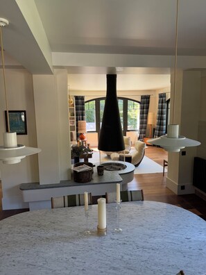 A modern living room with a fireplace, a round marble table, and a cozy seating area. - Family home 5 minutes from the lake and in the heart of Talloires village (Talloires-Montmin)