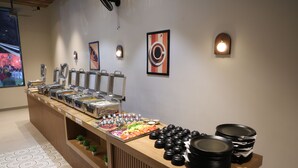 A buffet setup with various food items and serving utensils. - VANU GROUP OF HOTEL - GRANDSON (Jaipur)