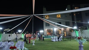 An outdoor event with a tent, tables, chairs, and guests. - VANU GROUP OF HOTEL - GRANDSON (Jaipur)