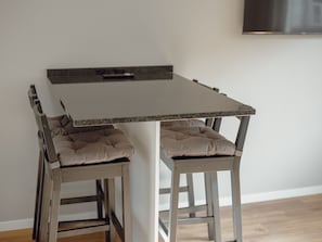 A dining table with two chairs, each with a cushioned seat. - Apartment  by Interhome (Porto)