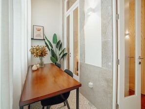 A wooden dining table with chairs, a vase with flowers, and a potted plant. - Apartment  by Interhome (Porto)