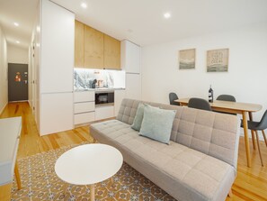 Een modern appartement met een woonkamer, eetgedeelte, kitchenette en een kleine keuken.