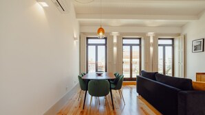 A modern living space with a dining area, a sofa, and large windows. - Apartment  by Interhome (Porto)
