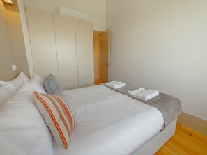 Habitació d'hotel amb un llit, almoines, un armari i una porta al bany.
