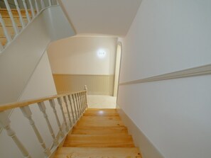 Una escalera de madera con barandillas blancas que lleva a una plataforma.