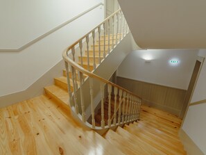 Eine Holztreppe mit weißen Geländern, die zu einer Zwischenebene führt.