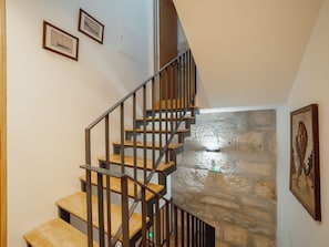 A staircase with wooden steps and metal railings, leading to a stone wall. - Apartment  by Interhome (Porto)