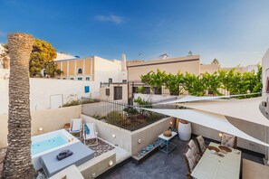 Una terraza en la azotea con piscina, zona de estar y vistas de los edificios circundantes.