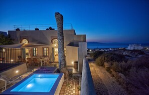 Eine moderne Villa mit Pool, Sitzgelegenheit im Freien und Meerblick.