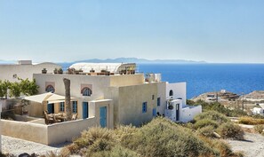 Ein Gebäude an der Küste mit mehreren Etagen, Außenplätzen und Blick auf das Meer.