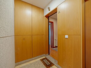 Un couloir avec des armoires en bois et une porte donnant sur une autre pièce.